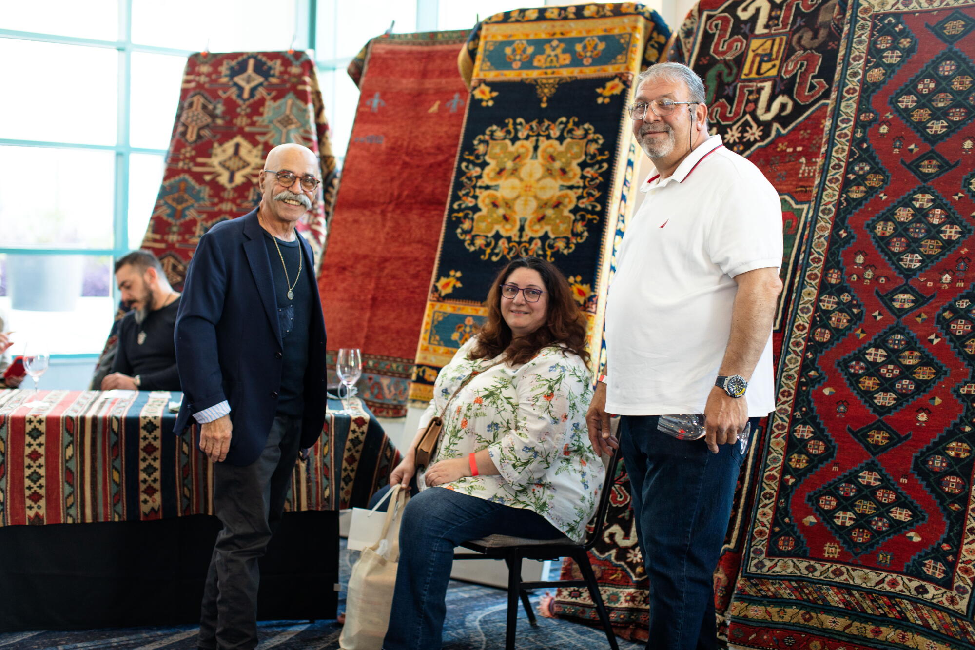 Exhibitors and guests beside patterned rugs at GiniFest 2023 in Burbank